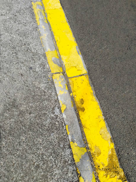 istock Yellow line in poor condition on asphalt road texture background. Damaged Asphalt road texture with yellow line. 1241480399