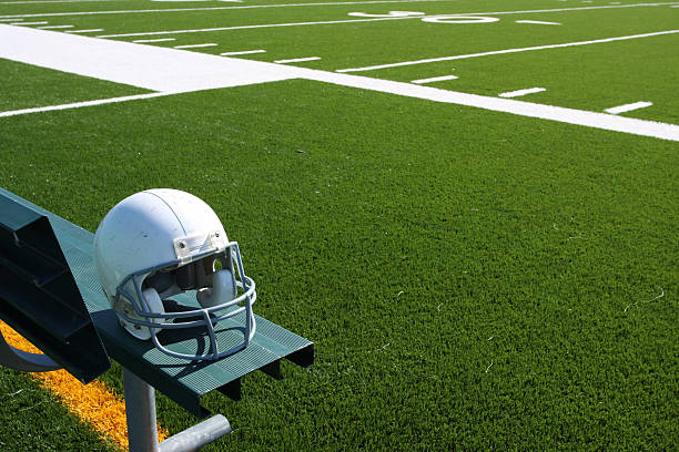 American Football Helmet on the Bench with the field in the background