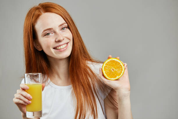 istock smiling awesome girl drinking orange juice 1241487113