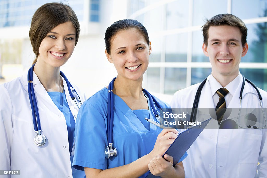 Young doctors Young doctors standing against a hospital building Adult Stock Photo