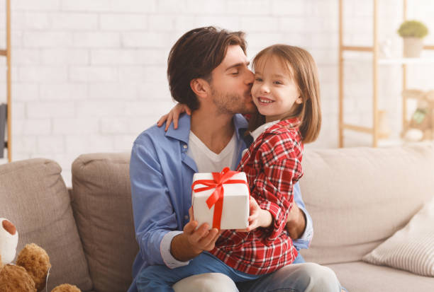 istock Loving little daughter giving her daddy present 1241491036