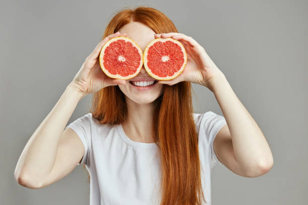 istock charming girl having fun with fruit 1241492744