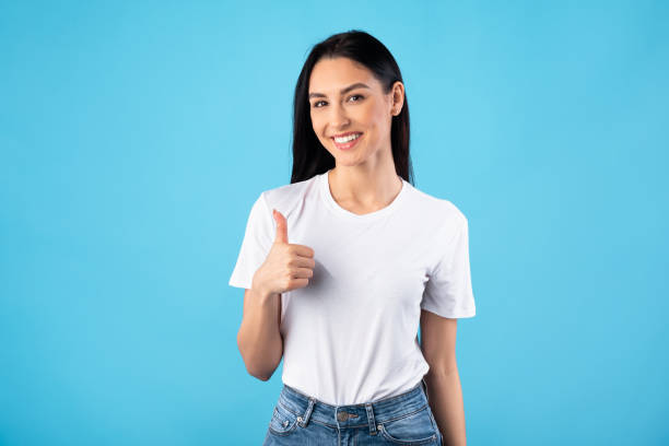 istock Young woman showing thumb up and smiling 1241493814