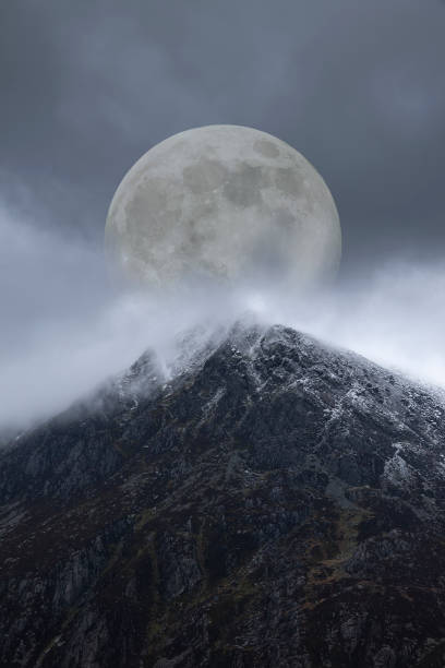 istock Epic digital composite image of Supermoon above mountain range giving very surreal fantasy look to the dramatic landscape image 1241495592