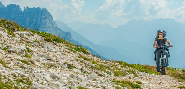 Sport and Recreation. Caucasian Men Riding on Mountain Bike. Scenic Mountain Trail. Panoramic Photo.