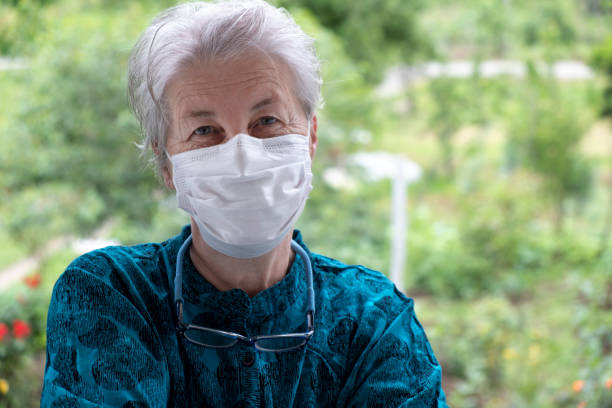 istock Senior woman smiling behind the mask 1241506763