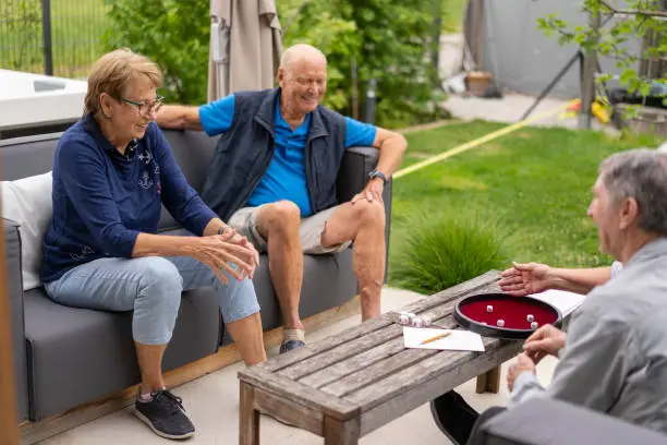 Photo of seniors hanging out in back yard playing poker dice