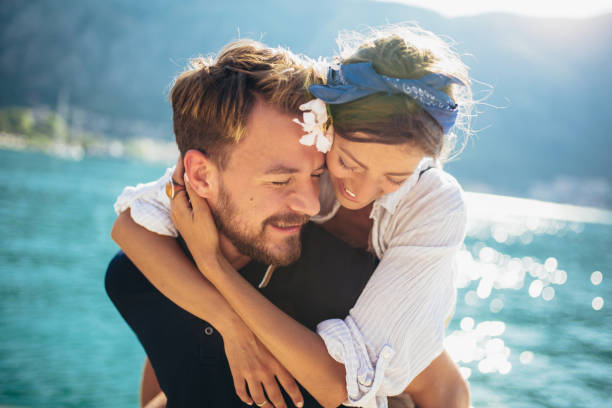 istock Handsome young man giving piggyback ride to girlfriend on beach. 1241518010