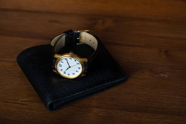 istock Retro wristwatch lie on a black leather wallet. 1241519611