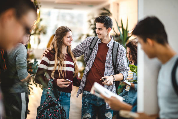 istock Happy high school couple walking down the hallway. 1241525034