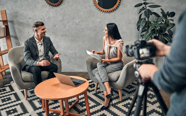 female journalist interviewing business man - reportagem imagens e fotografias de stock