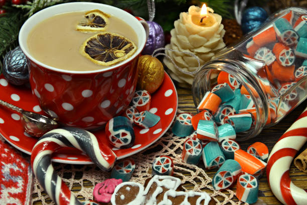 istock Red cup of tea with dessert, candy and candle on festive table. 1241528265