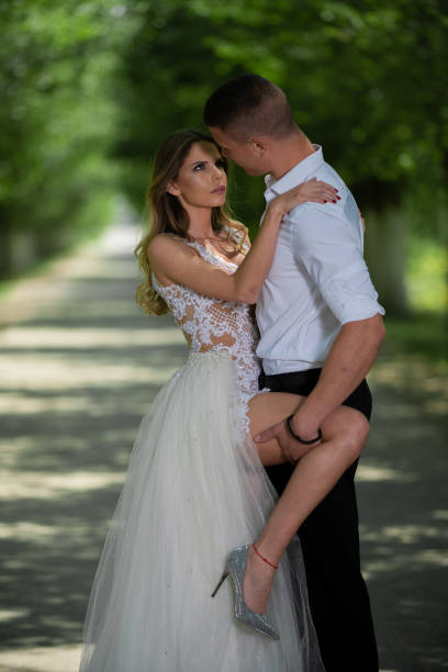 istock Beautiful wedding couple outdoors in front of car 1241541200