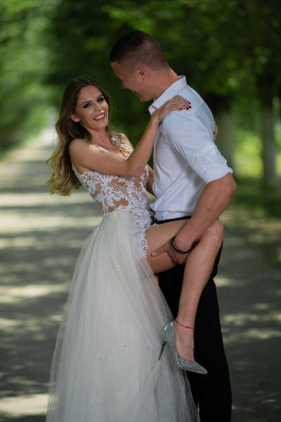 istock Beautiful wedding couple outdoors in front of car 1241542648
