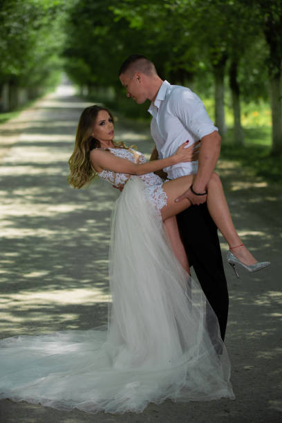 istock Beautiful wedding couple outdoors in front of car 1241543329