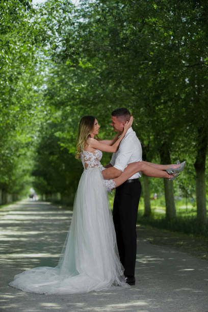 istock Beautiful wedding couple outdoors in front of car 1241545007