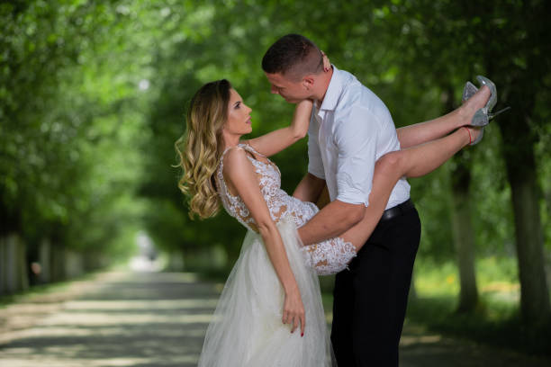 istock Beautiful wedding couple outdoors in front of car 1241545237