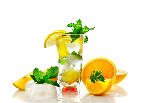 Lemon and orange cocktail with mint leaves in glass on white background