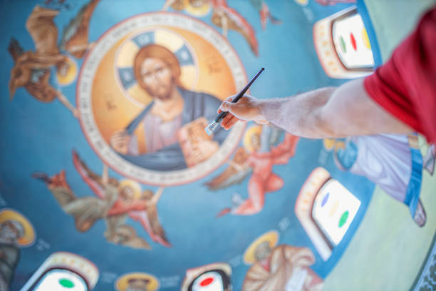 istock Man reaches church ceiling with a paintbrush 1241566596