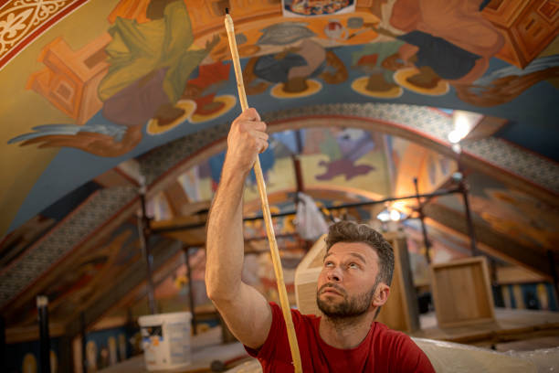 талантливый художник-мужчина рисует в церкви - restoring painting working church стоковые фото и изображения