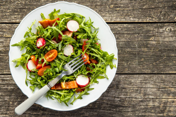 istock Fresh arugula salad with radishes, tomatoes and red peppers. 1241606755
