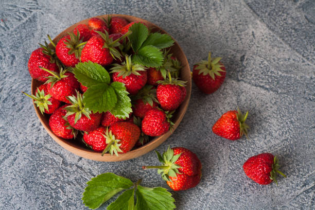 istock Red strawberies in a wooden bowl 1241612358