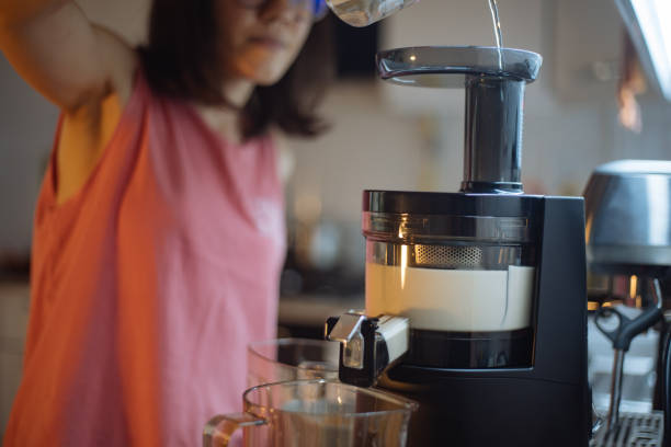 donna che fa latte di mandorla fatto in casa - blender food processor white isolated foto e immagini stock