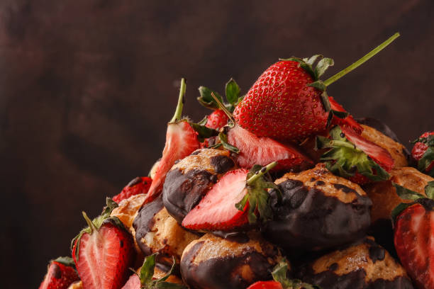 istock Cake of eclairs and fresh strawberries, poured with chocolate 1241614045