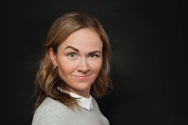 istock Happy woman grimacing on black background 1241614588
