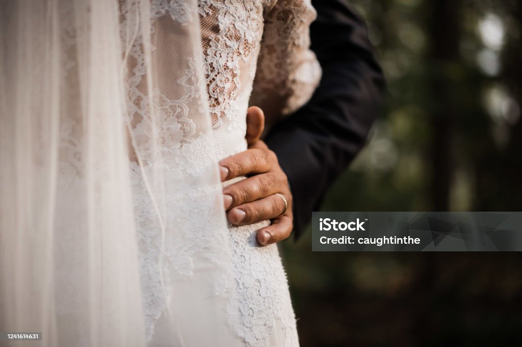 photo of a wedded couple standing in nature a wedded couple standing in nature Wedding Stock Photo