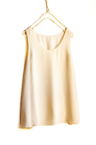 istock light beige or white tank top hanging on a hanger in a white wall. 1241622536