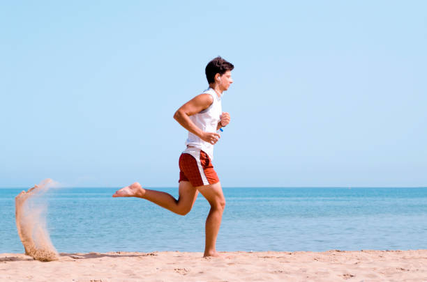 Man jogging on the sand beach by the sea