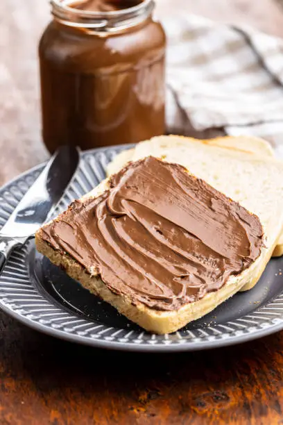 Toast bread with hazelnut spread. Sweet chocolate cream on plate.