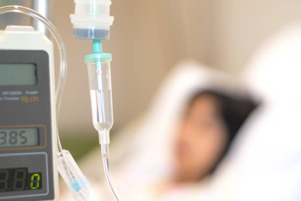 paciente infantil con línea intravenosa en sueño en la mano en la cama del hospital. concepto de atención médica para paliativa - suero fotografías e imágenes de stock