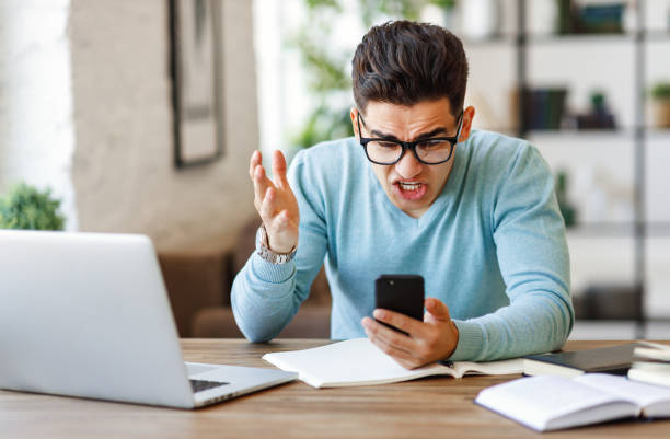 istock Angry ethnic freelancer reading message on smartphone 1241650761