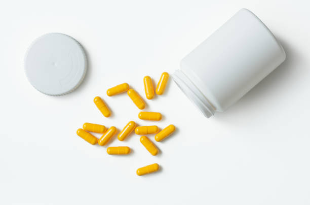 istock An open bottle with yellow tablets on a white background. The view from the top. 1241662391