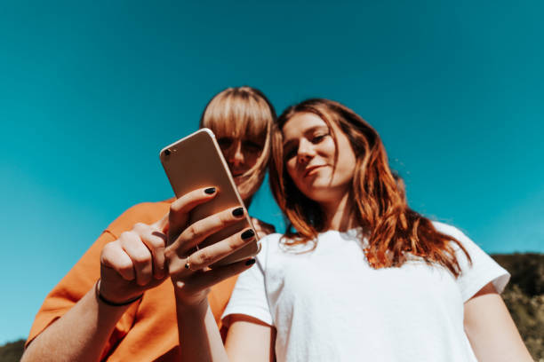 istock Young women checking social media posts on mobile phone 1241662986
