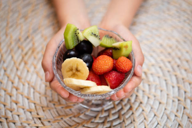 istock Child's hand holding cut fruit 1241675549