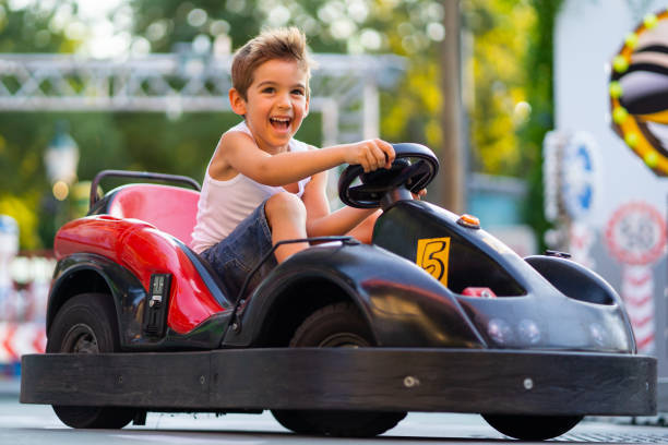 カートに乗って楽しむ興奮若い男の子 - go cart ストックフォトと画像