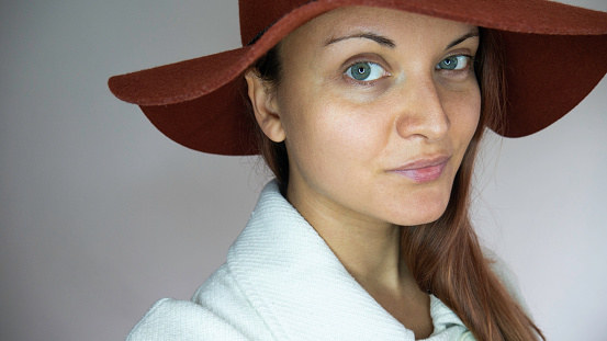 Portrait of a young Caucasian woman with a red hat.