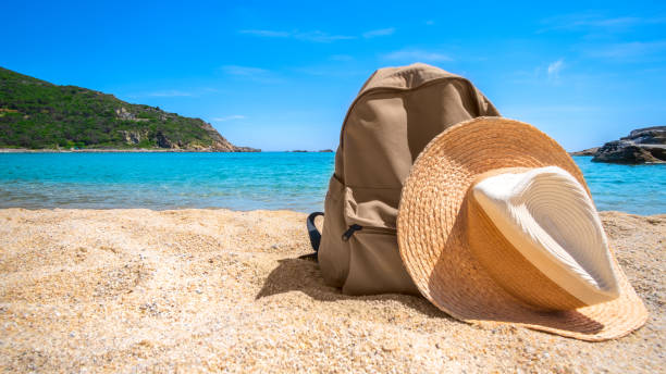 istock Beach straw hat and backpack  on the sea ocean beach backdrop. 1241688402