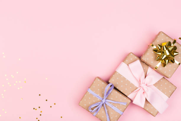 istock Gift or gift box and stars confetti on a pink table from above. Flat composition for birthday, mothers day or wedding. 1241688440