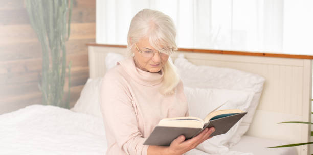 istock Senior woman reads, concentrated in a book. 1241689003