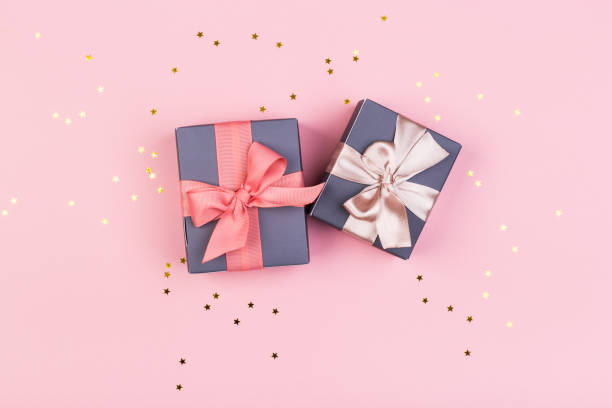 istock Gift or gift box and stars confetti on a pink table from above. Flat composition for birthday, mothers day or wedding. 1241690093