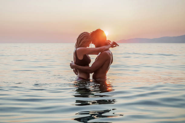 Romantic sunset Silhouette of a couple in love in the sea romantic activity stock pictures, royalty-free photos & images