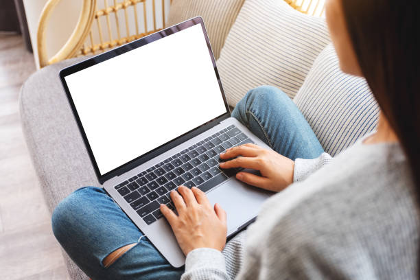 istock a woman working and typing on laptop computer with blank screen while sitting on a sofa at home 1241698650