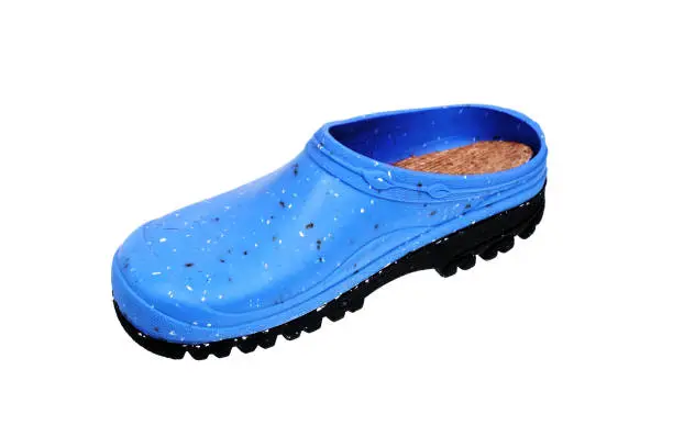 Photo of Rubber shoes isolate on a white background. Colored rubber slippers on a tractor sole. Shoes for the garden, beach and housework.