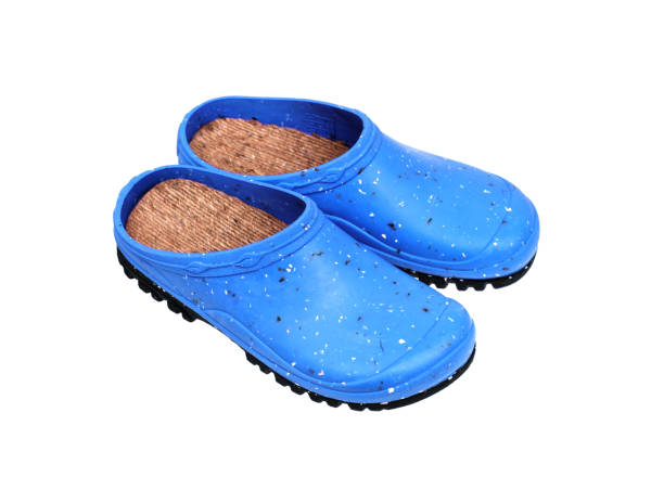 Photo of Rubber shoes isolate on a white background. Colored rubber slippers on a tractor sole. Shoes for the garden, beach and housework.