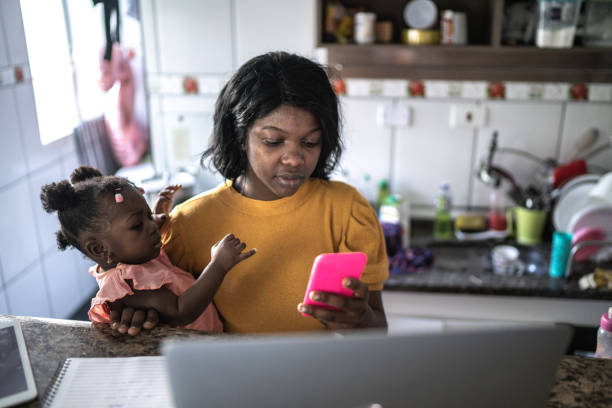 Mother doing homeoffice while holding her baby girl