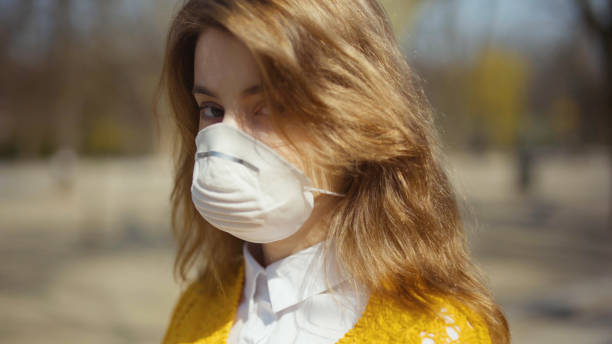 istock Young student wearing antibacterial mask standing in a park. 1241711907